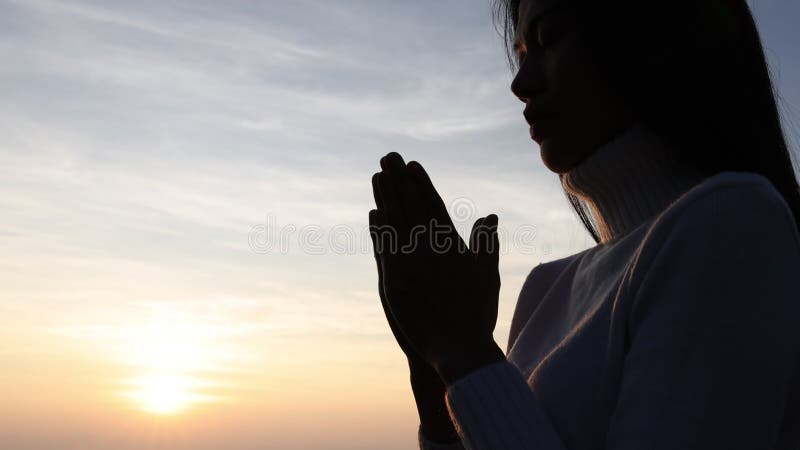 Het silhouet van een vrouw bidt tot god op de berg. het bidden van handen met geloof in religie en geloof in god over zegen