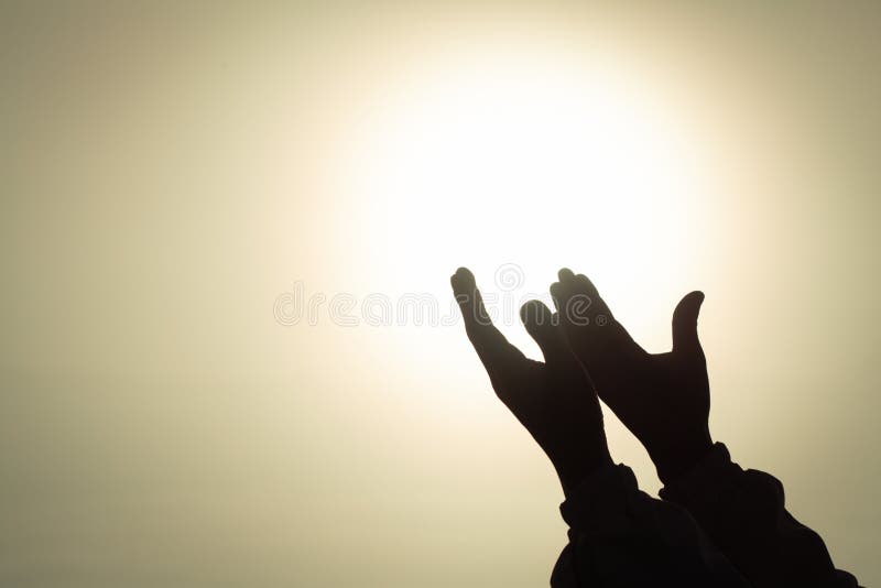 Het silhouet van jonge menselijke handen open palm aanbidt omhoog en biddend aan god bij zonsopgang, Christian Religion-concepten