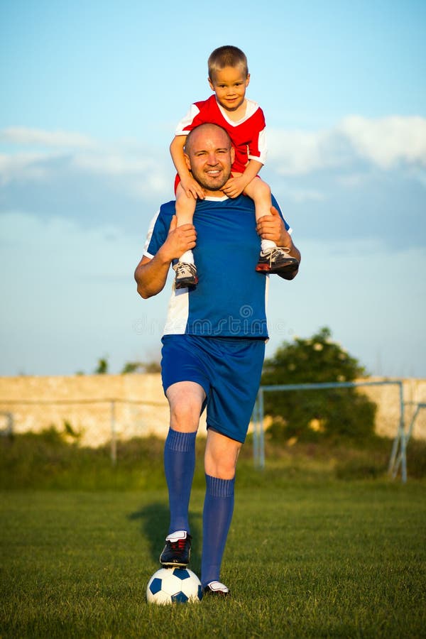 Het speelvoetbal van de vader en van de zoon stock afbeeldingen Het speelvoetbal van de vader en van de zoon stock afbeeldingen
