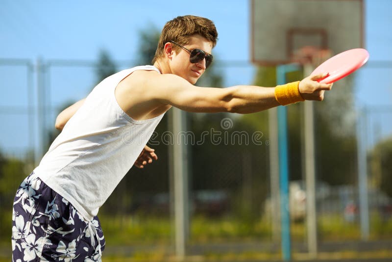 Young handsome man is playing frisbee in the park. Young handsome man is playing frisbee in the park