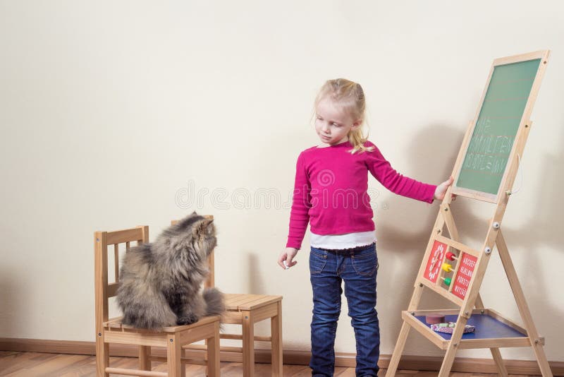 Het spelen van het kind met kattenschool. stock afbeeldingen Het spelen van het kind met kattenschool. stock afbeeldingen