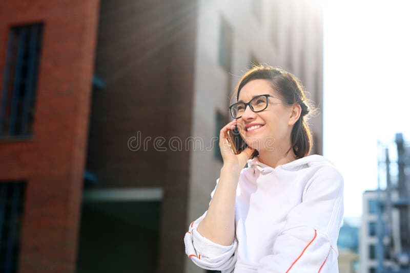 Het spreken op een mobiele telefoon Gelukkige, glimlachende jonge vrouw die op de telefoon spreken royalty-vrije stock afbeelding Het spreken op een mobiele telefoon Gelukkige, glimlachende jonge vrouw die op de telefoon spreken royalty-vrije stock afbeelding