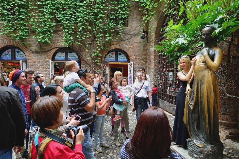 Unidentified tourists near Juliet's statue on April 26, 2013 in Verona, Italy. The Juliet's statue is one of most popular and symbolic tourist attraction in Verona, Italy. Unidentified tourists near Juliet's statue on April 26, 2013 in Verona, Italy. The Juliet's statue is one of most popular and symbolic tourist attraction in Verona, Italy.