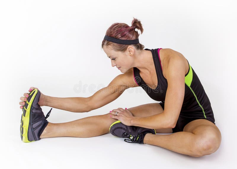 Strong toned and muscular female stretching before her workout. Beautiful woman on a white background. Strong toned and muscular female stretching before her workout. Beautiful woman on a white background