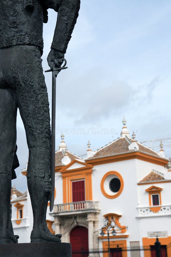 Fragment of matador statue against famous Seville bullfight arena, Spain. Fragment of matador statue against famous Seville bullfight arena, Spain