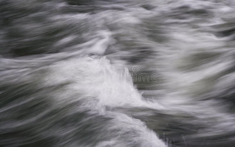 Abstract image of flowing water rushing by in a river. Abstract image of flowing water rushing by in a river.