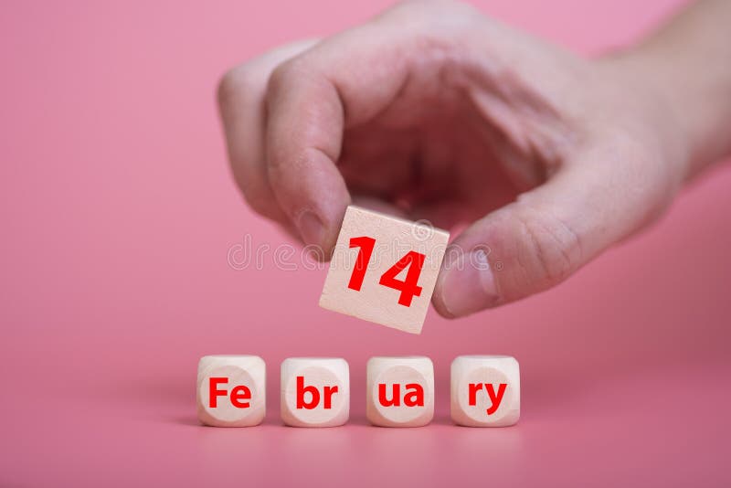 The symbol of Valentine`s Day on February 14. A wooden block with the inscription February 14. The hand holds a cube with the number 14. The concept of Valentine`s Day. The symbol of Valentine`s Day on February 14. A wooden block with the inscription February 14. The hand holds a cube with the number 14. The concept of Valentine`s Day