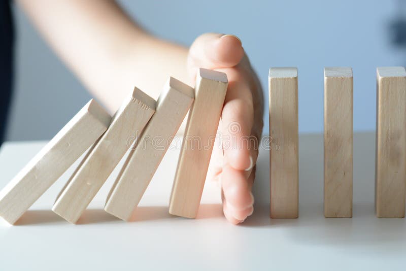 Stopping the domino effect concept with a business solution and intervention. Stopping the domino effect concept with a business solution and intervention