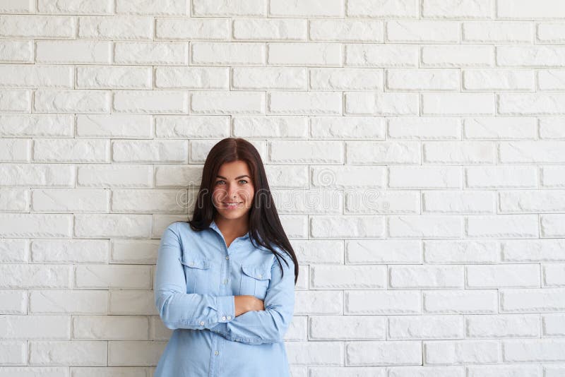 Het tevreden jonge vrouw houden bewapent gekruist en glimlachend terwijl tribune stock foto's Het tevreden jonge vrouw houden bewapent gekruist en glimlachend terwijl tribune stock foto's