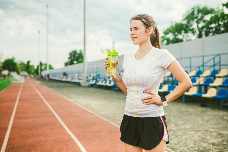 Het thema is sport en gezondheid De mooie jonge Kaukasische vrouw met de grote agent van de borstenatleet bevindt zich rustend bi stock foto's Het thema is sport en gezondheid De mooie jonge Kaukasische vrouw met de grote agent van de borstenatleet bevindt zich rustend bi stock foto's