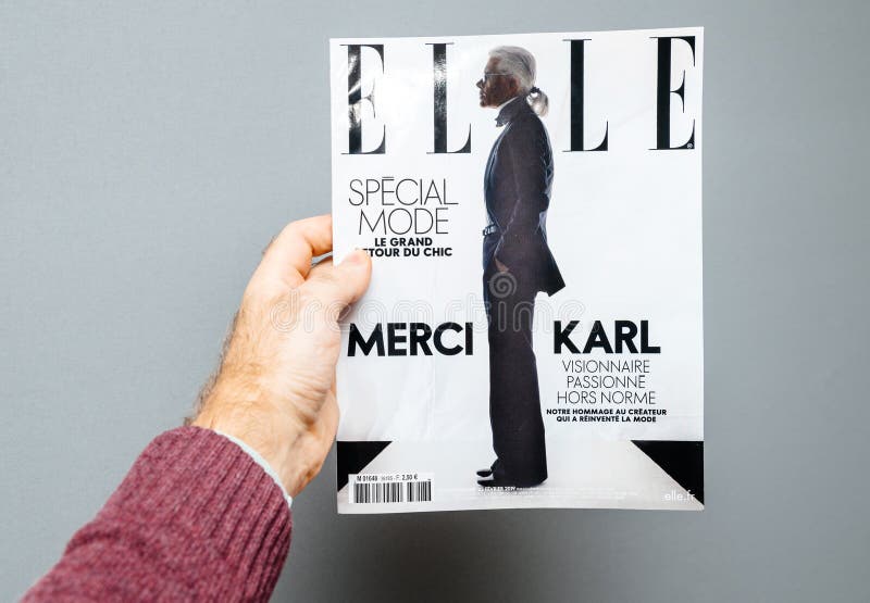 Het tijdschrift die van Elle van de mensenholding de dood van dekkingskarl lagerfeld kenmerken stock fotografie Het tijdschrift die van Elle van de mensenholding de dood van dekkingskarl lagerfeld kenmerken stock fotografie