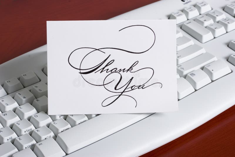 Close-up of a computer white keyboard with thank you cards. Close-up of a computer white keyboard with thank you cards