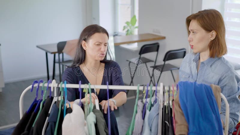 Het twee vrouwenmeisje demonteert garderobe De meisjes proberen op verschillende kleren en beslissen hoe te zich omhoog te kleden