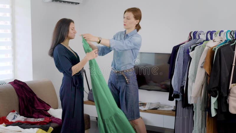 Het twee vrouwenmeisje demonteert garderobe De meisjes proberen op verschillende kleren en beslissen hoe te zich omhoog te kleden