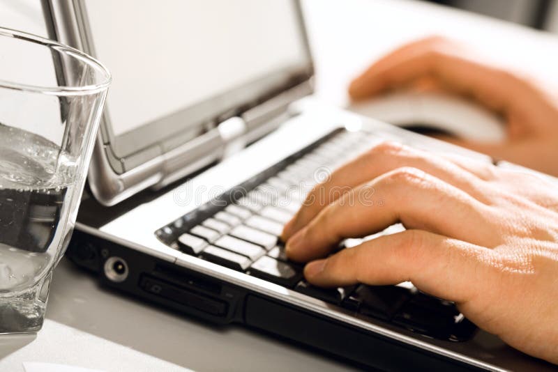 Close-up of male hands typing a letter on keyboard of laptop. Close-up of male hands typing a letter on keyboard of laptop