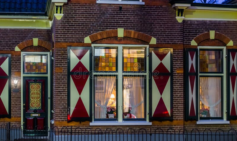 Het typische Nederlandse luxueuze huis in de stijl van het land, dure architectuur in Nederland, stak huis met vensters bij nacht stock afbeelding Het typische Nederlandse luxueuze huis in de stijl van het land, dure architectuur in Nederland, stak huis met vensters bij nacht stock afbeelding