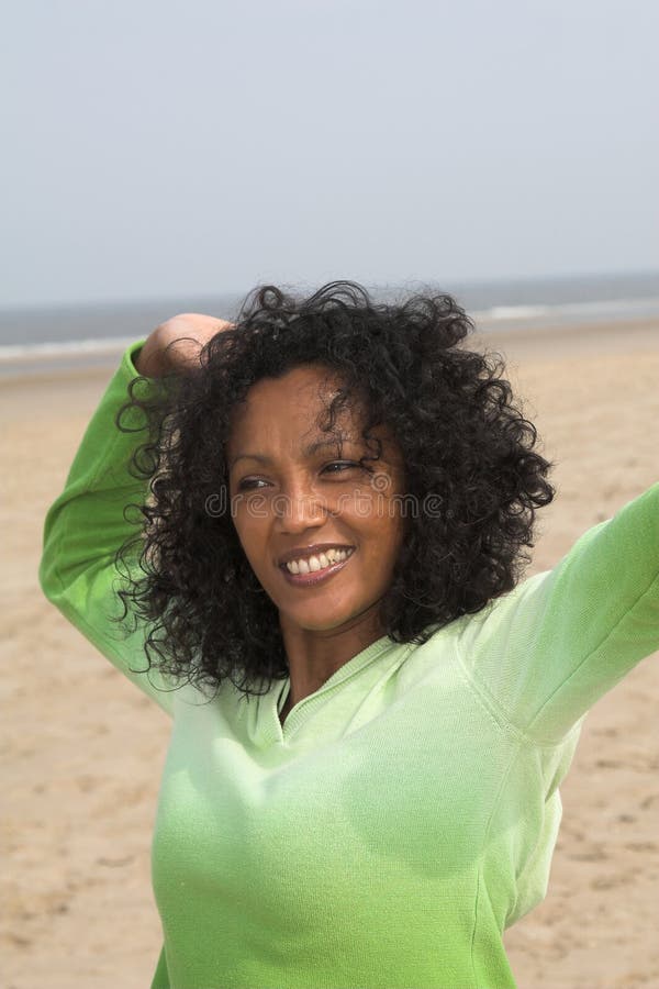 Beautiful black woman stretching herself at the beach. Beautiful black woman stretching herself at the beach