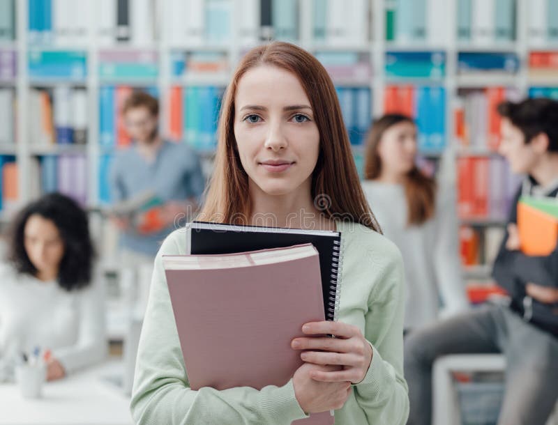 Het universitaire student stellen met notitieboekjes stock fotografie Het universitaire student stellen met notitieboekjes stock fotografie
