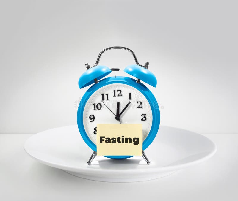 Fasting time, alarm clock on white plate. Fasting time, alarm clock on white plate