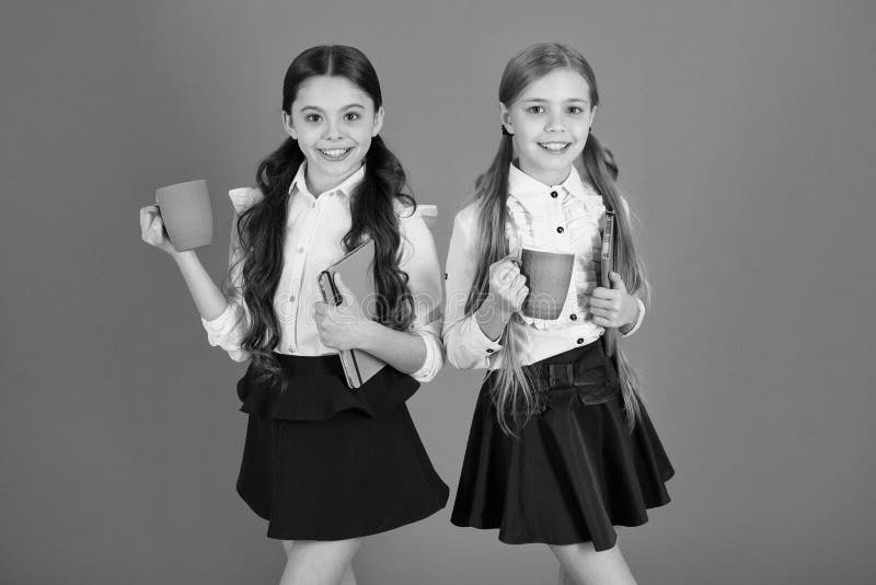 Het verbeteren van hun energie en stemming De kleine meisjes genieten van de Leuke schoolmeisjes die van het schoolontbijt koppen royalty-vrije stock foto Het verbeteren van hun energie en stemming De kleine meisjes genieten van de Leuke schoolmeisjes die van het schoolontbijt koppen royalty-vrije stock foto