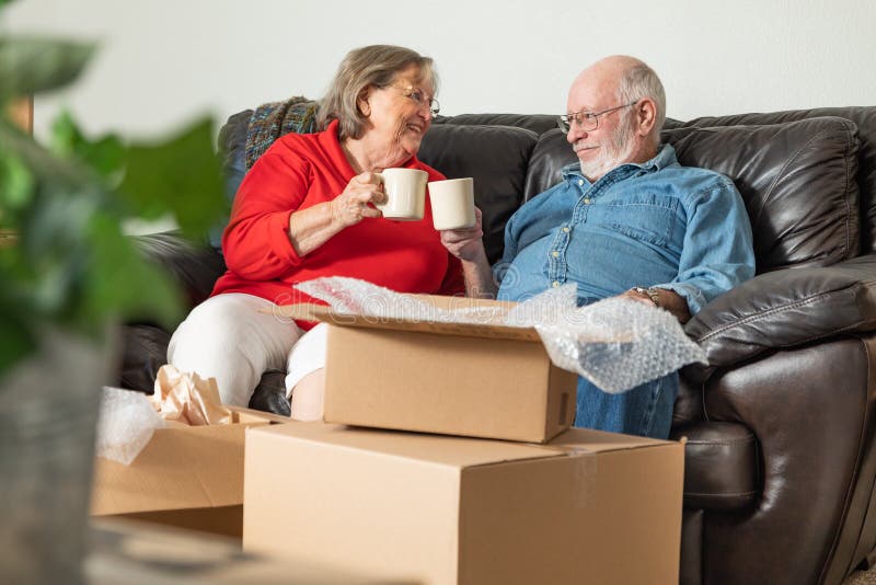 Het vermoeide Hogere Volwassen Paar Ontspannen op Laag die van Koffie genieten stock fotografie Het vermoeide Hogere Volwassen Paar Ontspannen op Laag die van Koffie genieten stock fotografie