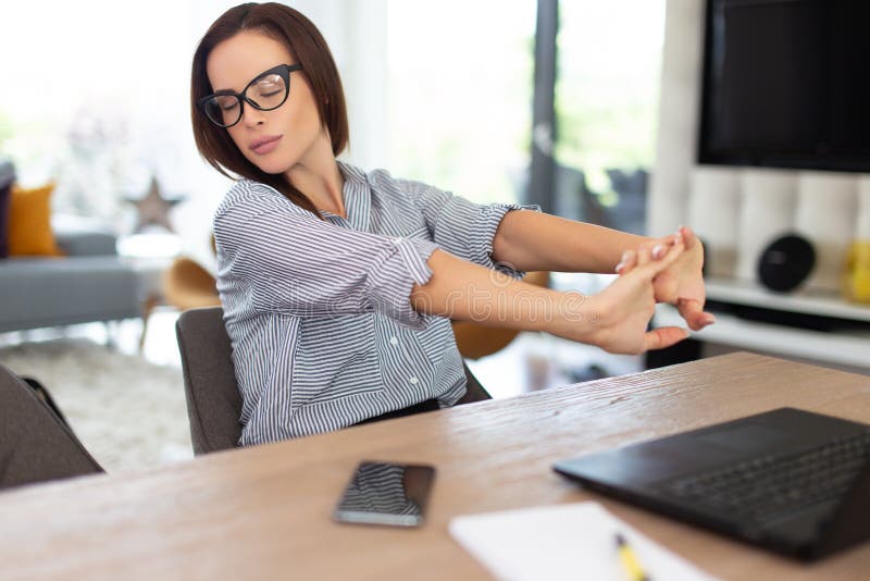 Het vermoeide onderneemster uitrekken zich bij laptop binnen stock fotografie Het vermoeide onderneemster uitrekken zich bij laptop binnen stock fotografie