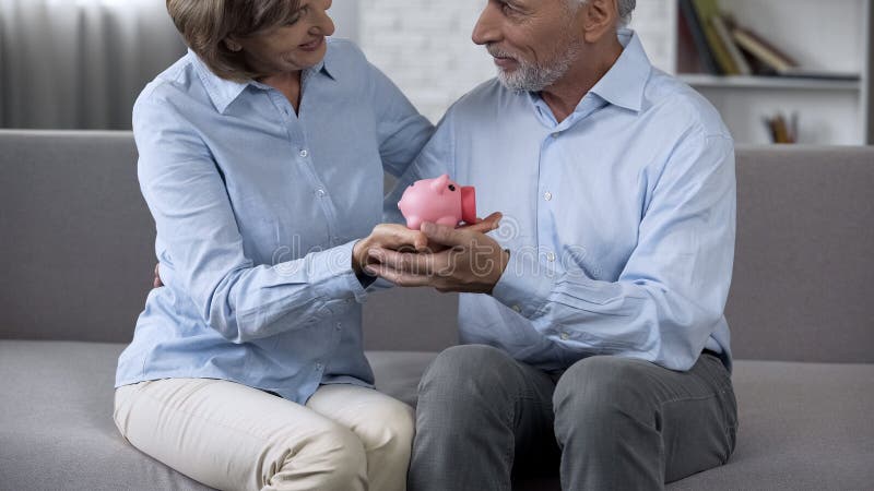 Het verouderen paarzitting op laag met spaarvarken, besparingsgeld voor droom, toekomst stock foto Het verouderen paarzitting op laag met spaarvarken, besparingsgeld voor droom, toekomst stock foto
