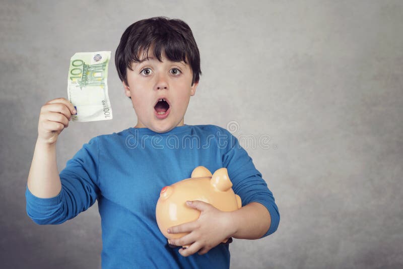 Het verraste geld van de kindbesparing in een spaarvarken stock afbeelding Het verraste geld van de kindbesparing in een spaarvarken stock afbeelding
