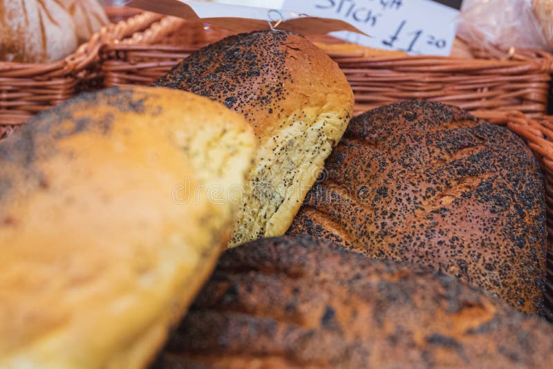 Het vers gebakken knapperige brood van het papaverzaad op vertoning bij een lokale markt in Chester, Chestershire, het UK royalty-vrije stock foto Het vers gebakken knapperige brood van het papaverzaad op vertoning bij een lokale markt in Chester, Chestershire, het UK royalty-vrije stock foto