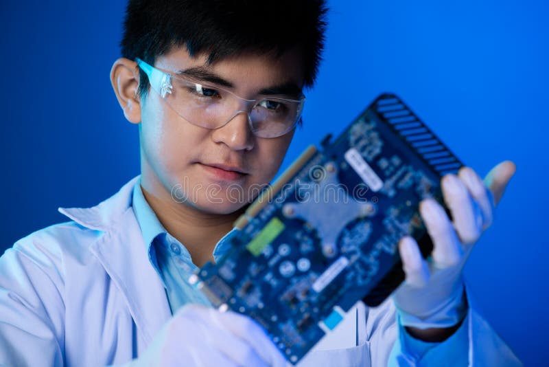 Vertical image of a an engineer analyzing the computer video card on the foreground. Vertical image of a an engineer analyzing the computer video card on the foreground