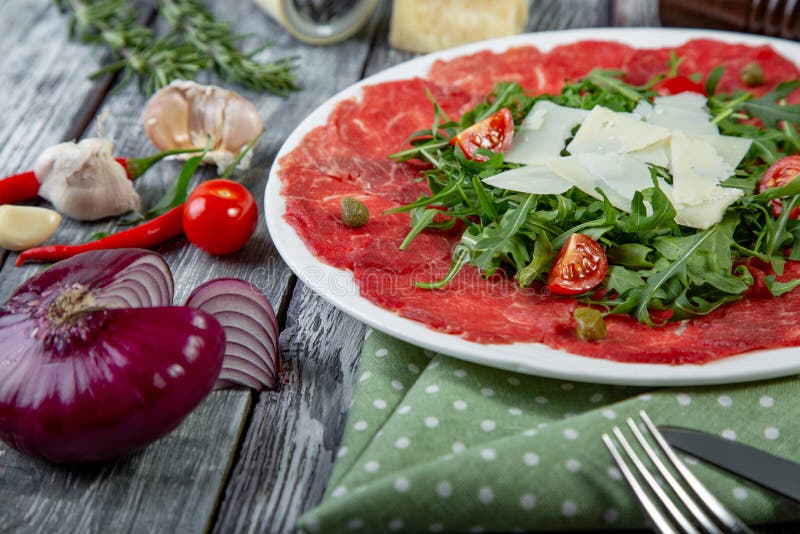Het vlees van close-upcarpaccio met arugula en plakken van parmezaanse kaaskaas royalty-vrije stock fotografie Het vlees van close-upcarpaccio met arugula en plakken van parmezaanse kaaskaas royalty-vrije stock fotografie