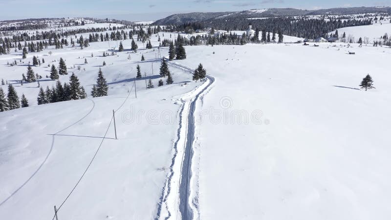 Het vliegen boven sneeuw behandelde weg in de bergen Lucht4k-hommelfilm