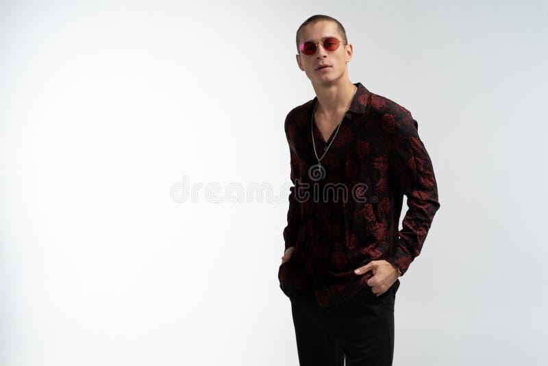 Het volledige lengteportret van het verbazen van de aantrekkelijke mens in modieuze in kleren, die rode zonnebril, het houden dra royalty-vrije stock fotografie Het volledige lengteportret van het verbazen van de aantrekkelijke mens in modieuze in kleren, die rode zonnebril, het houden dra royalty-vrije stock fotografie