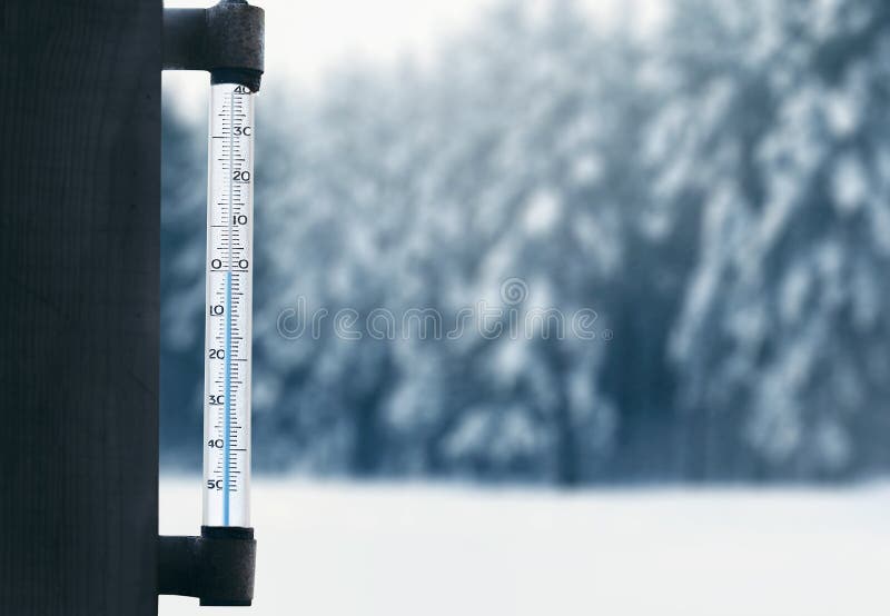 Het voorspellen en de winterweerseizoen, thermometer op glasvenster met vage sneeuw de winter bosachtergrond