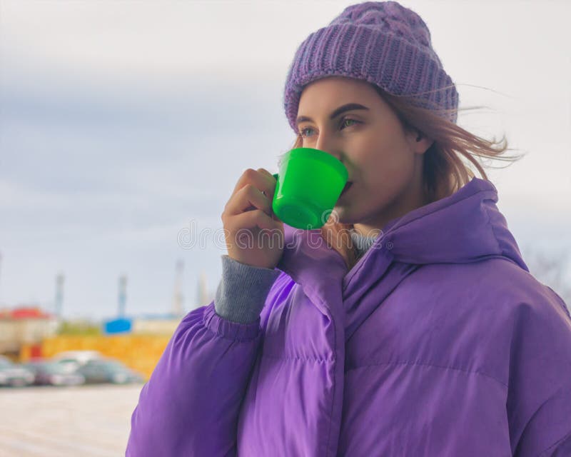 Het vrij jonge meisje drinkt koffie of thee, straat stock foto Het vrij jonge meisje drinkt koffie of thee, straat stock foto