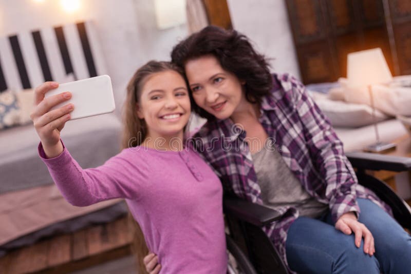 Het vrolijke verlamde vrouw en meisjes fotograferen stock afbeeldingen Het vrolijke verlamde vrouw en meisjes fotograferen stock afbeeldingen