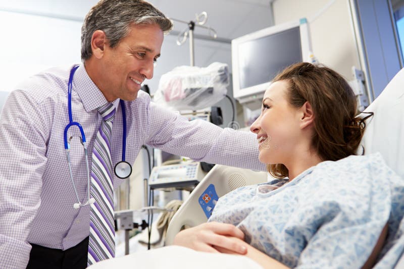 Het vrouwelijke Geduldige Spreken aan Mannelijke Adviseur In Emergency Room stock afbeeldingen Het vrouwelijke Geduldige Spreken aan Mannelijke Adviseur In Emergency Room stock afbeeldingen