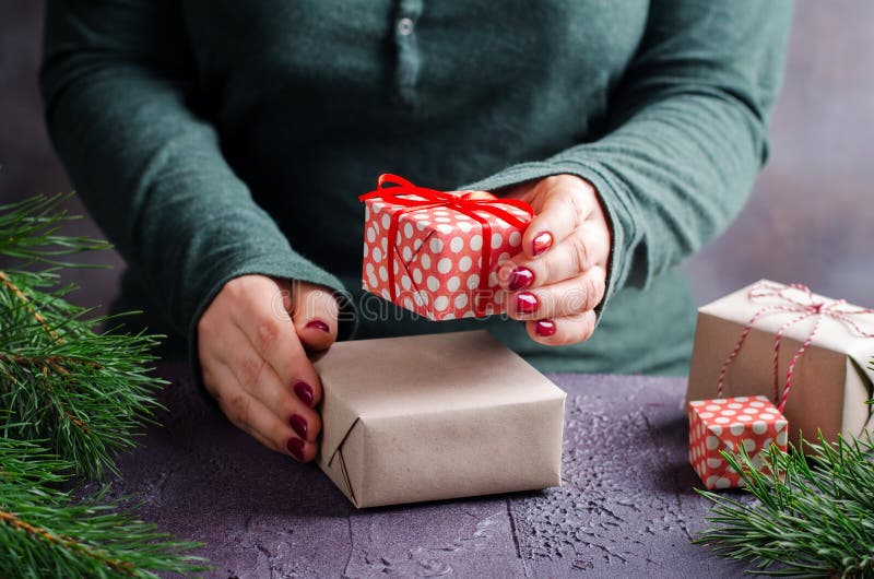 Het vrouwelijke handen verpakken en huidige Kerstmisgiften op donkere achtergrond royalty-vrije stock afbeelding Het vrouwelijke handen verpakken en huidige Kerstmisgiften op donkere achtergrond royalty-vrije stock afbeelding