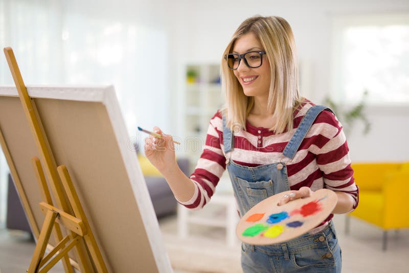 Het vrouwelijke kunstenaar schilderen op een canvas