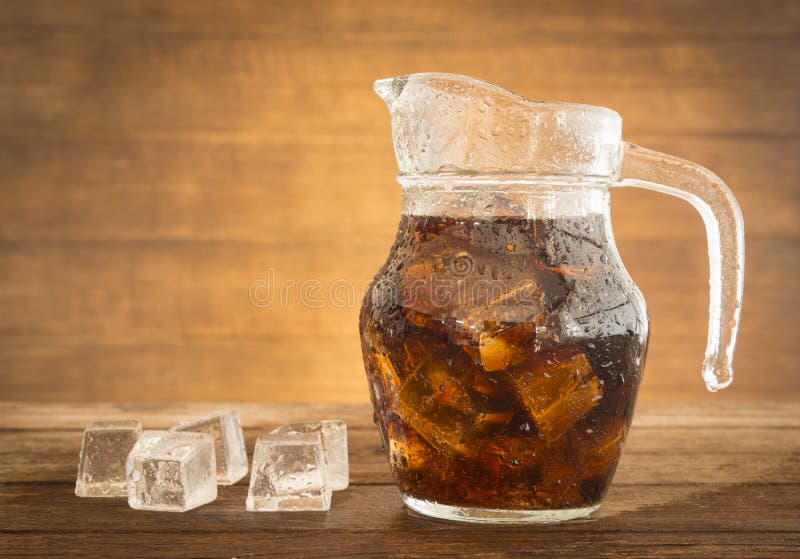 sparkling water in a jug with ice placed on a table of dark wood. sparkling water in a jug with ice placed on a table of dark wood.