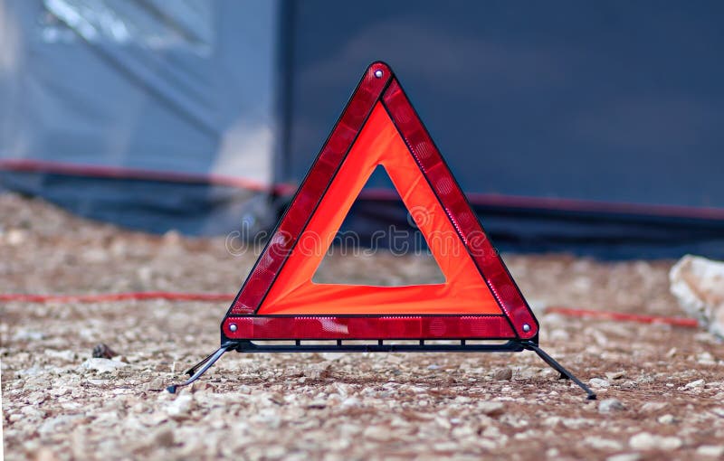 Het weerspiegelende rode bijkomende waakzame teken van de driehoeksauto