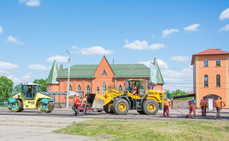 Het werkbrigade die de weg herstellen die de betonmolenhoogtepunt van het kruippakjeasfalt van verse asfaltbestrating en wegwals royalty-vrije stock afbeelding Het werkbrigade die de weg herstellen die de betonmolenhoogtepunt van het kruippakjeasfalt van verse asfaltbestrating en wegwals royalty-vrije stock afbeelding