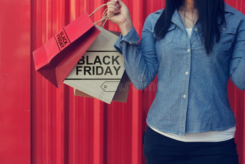 Het winkelen van Black Friday van de vrouwenholding zak op rode muurwandelgalerij royalty-vrije stock foto's Het winkelen van Black Friday van de vrouwenholding zak op rode muurwandelgalerij royalty-vrije stock foto's