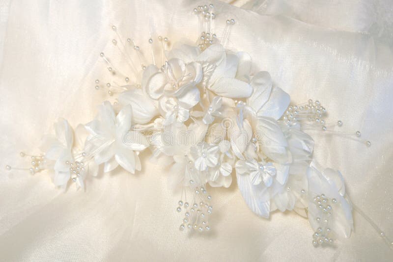 Headpiece of silk flowers lying on back of gown. Headpiece of silk flowers lying on back of gown.