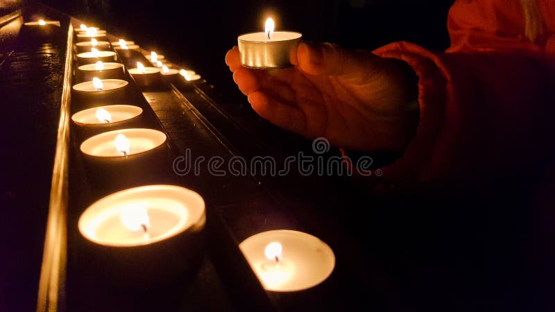 Het zetten van kaars op een basis in een kerk stock fotografie Het zetten van kaars op een basis in een kerk stock fotografie