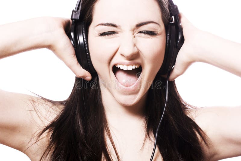 A pretty young woman listening to her headphones and singing. A pretty young woman listening to her headphones and singing.