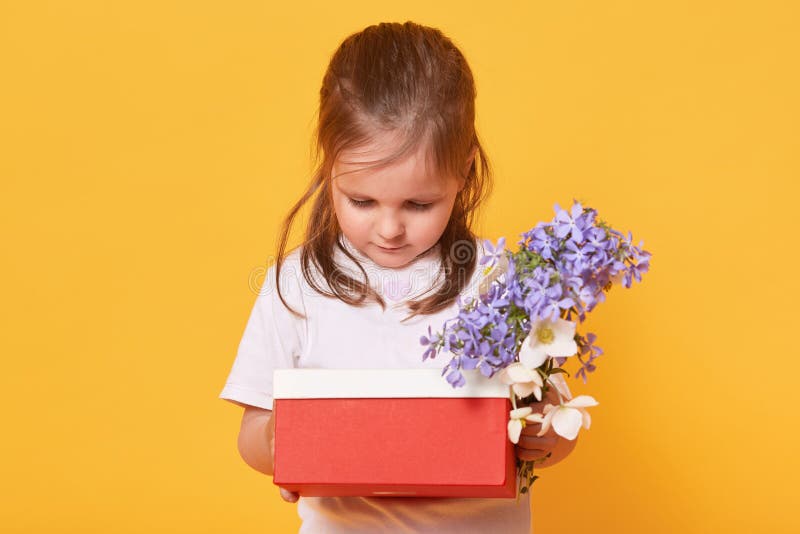 Het zoete kindmeisje die rode doos met heden en boeket van bloemen houden, peuter maakt zich terwijl het voorbereidingen treffen royalty-vrije stock afbeelding Het zoete kindmeisje die rode doos met heden en boeket van bloemen houden, peuter maakt zich terwijl het voorbereidingen treffen royalty-vrije stock afbeelding