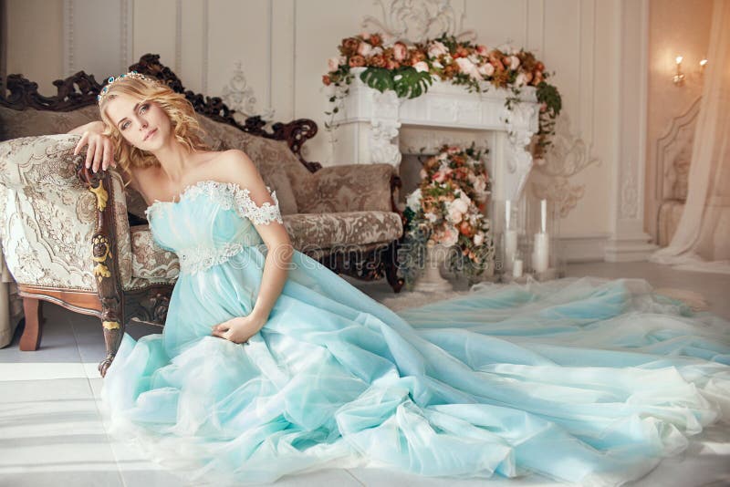 Het zwangere bruidblonde treft een moeder en een vrouw te worden voorbereidingen Lange turkooise kleding op een meisjeslichaam Kr stock fotografie Het zwangere bruidblonde treft een moeder en een vrouw te worden voorbereidingen Lange turkooise kleding op een meisjeslichaam Kr stock fotografie