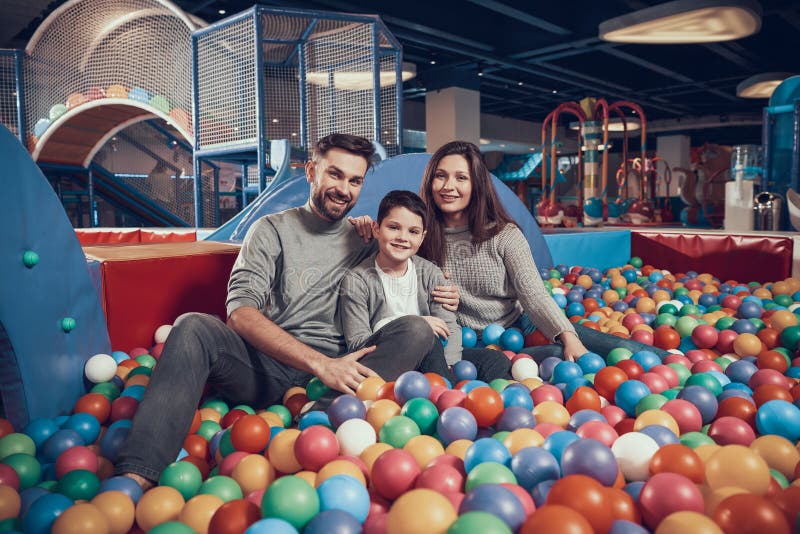 Heureuse famille s'asseyant dans la piscine avec des boules photo libre de droits Heureuse famille s'asseyant dans la piscine avec des boules photo libre de droits