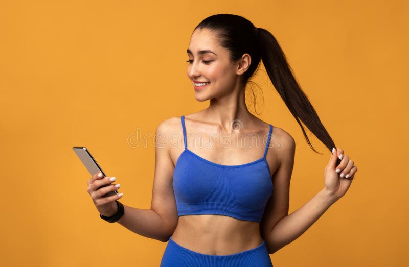 Heureuse femme sportive utilisant le téléphone cellulaire au studio image libre de droits